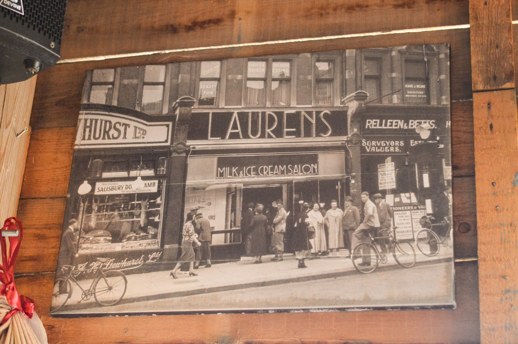 Historische foto van een winkelstraat aan de muur