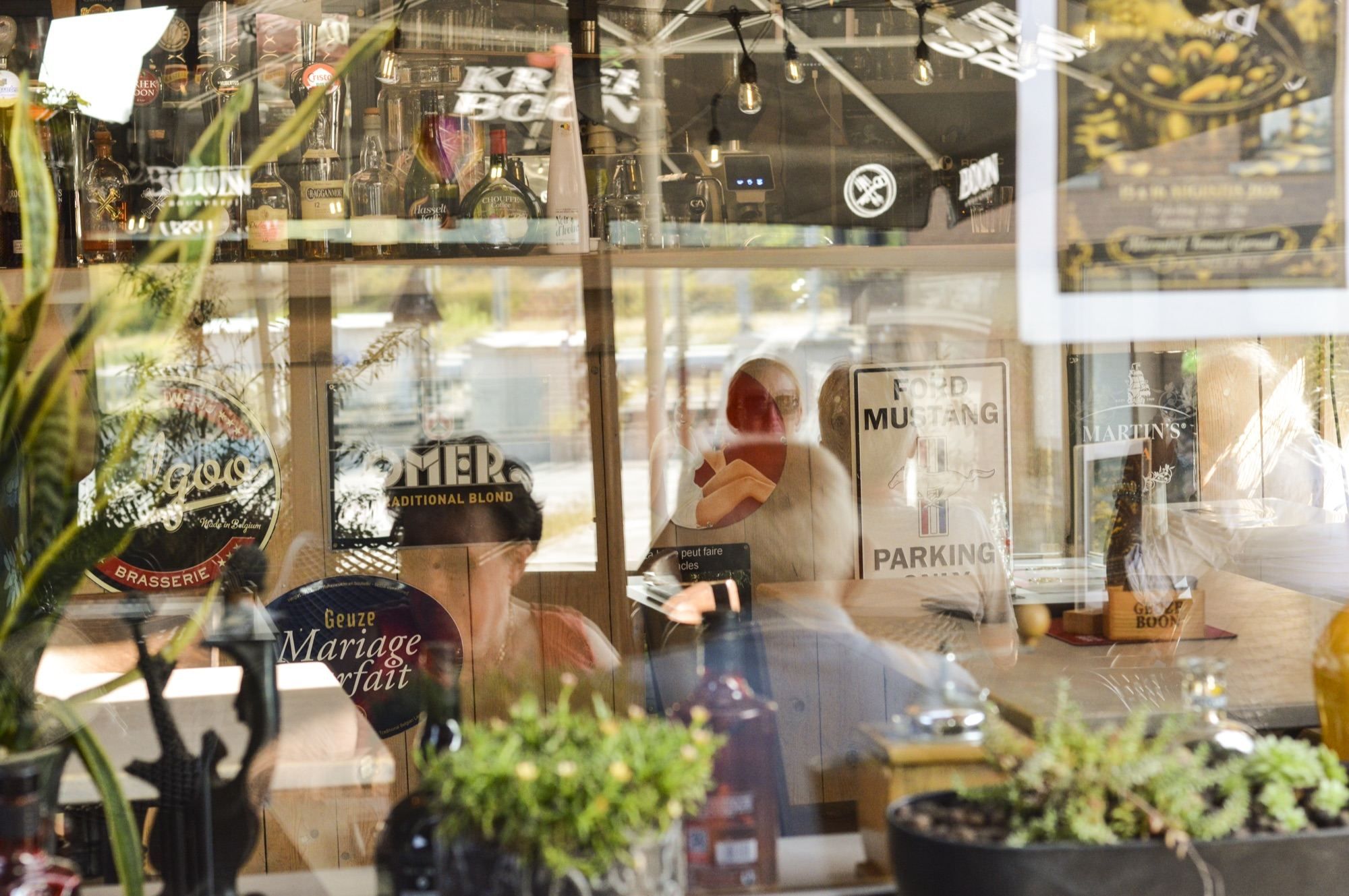 Het terras weerspiegeld in het raam van het café