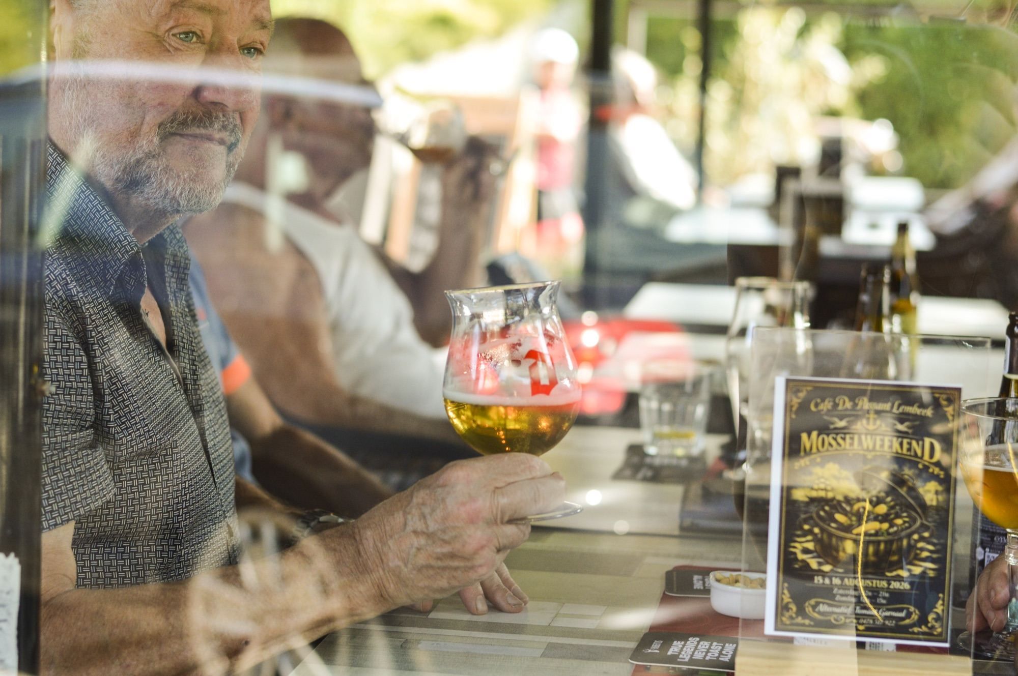 Stamgast met een glas bier aan het raam